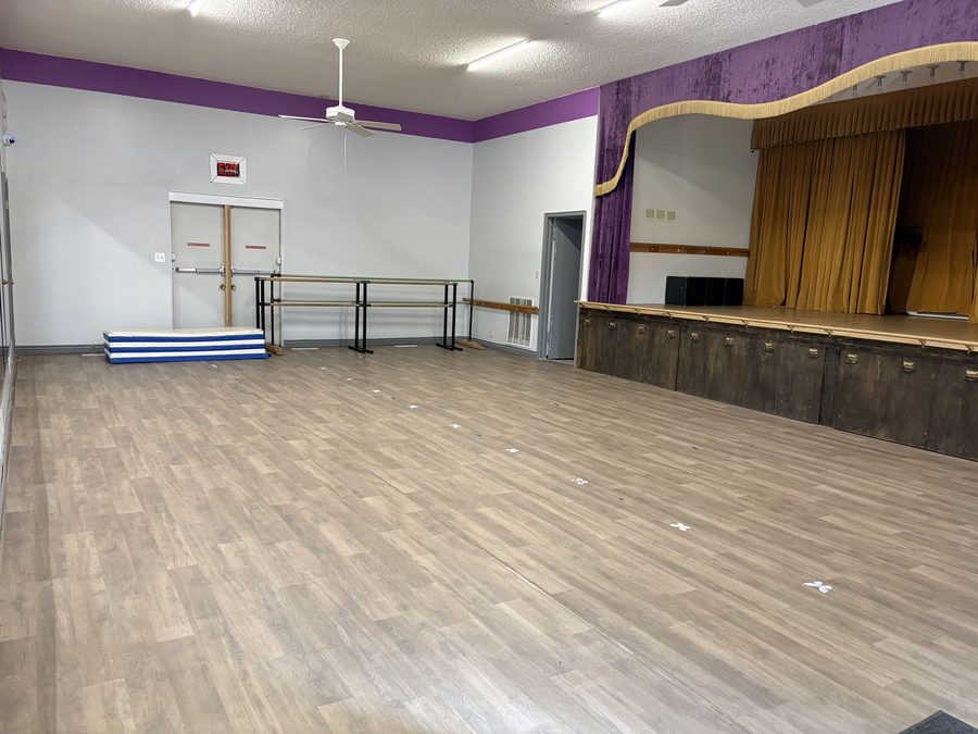 A second room at Syracuse Dance Academy with barres and a small stage